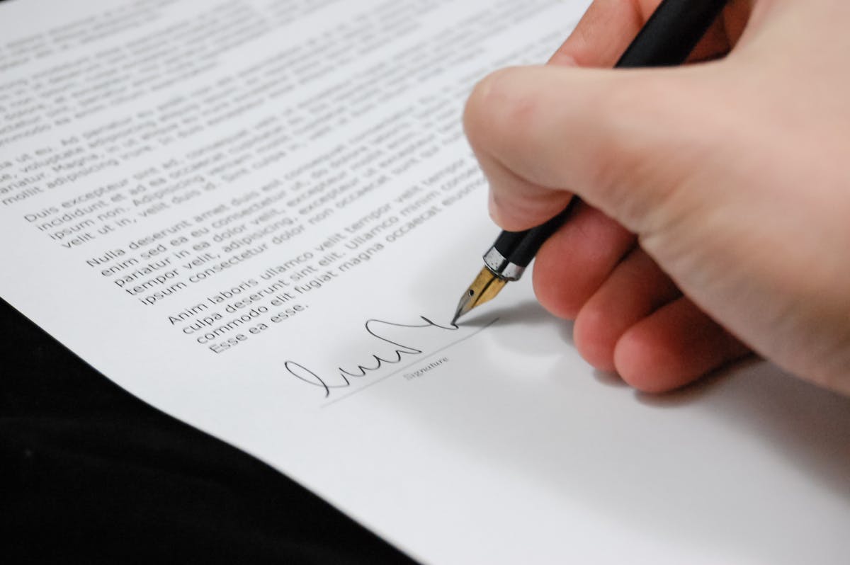 Personne signant un contrat formel avec un stylo plume