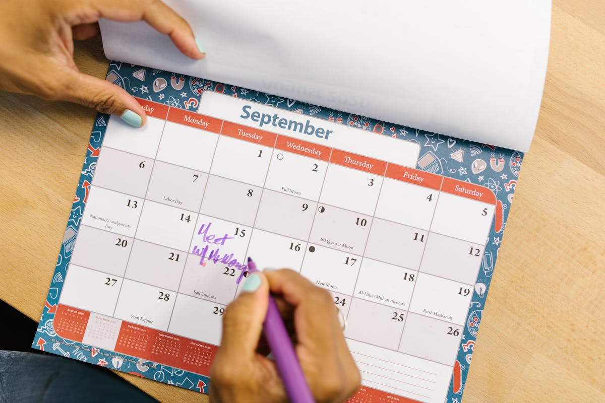 Personne marquant un calendrier avec un stylo violet